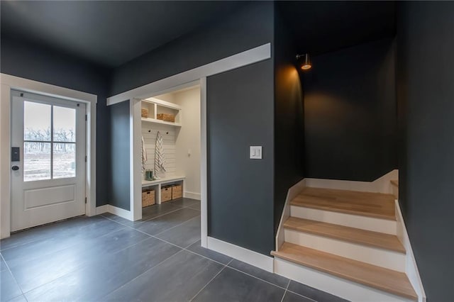 mudroom with baseboards and dark tile patterned floors