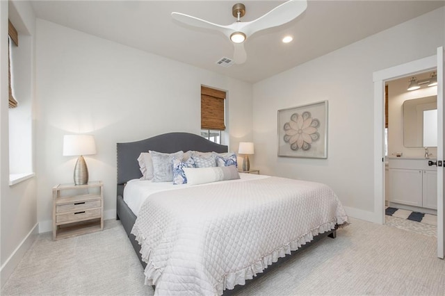 bedroom with visible vents, light carpet, ensuite bath, and baseboards