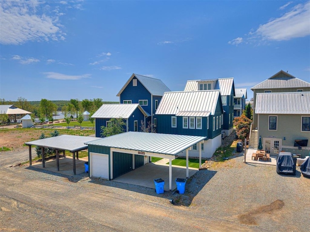 view of front of home featuring a carport, board and batten siding, an outdoor structure, metal roof, and a standing seam roof