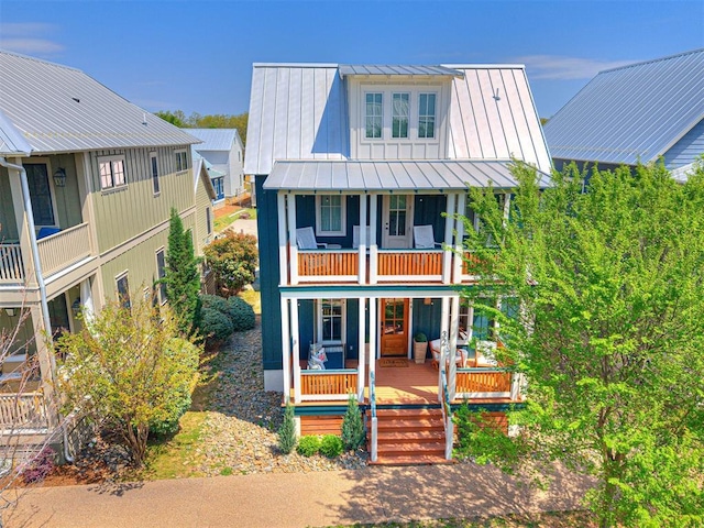 view of front facade with a porch, a standing seam roof, a balcony, and metal roof