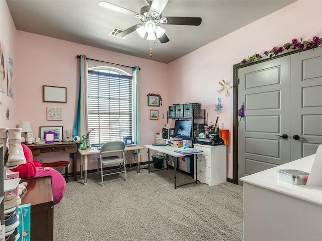 office featuring light colored carpet, baseboards, a ceiling fan, and visible vents