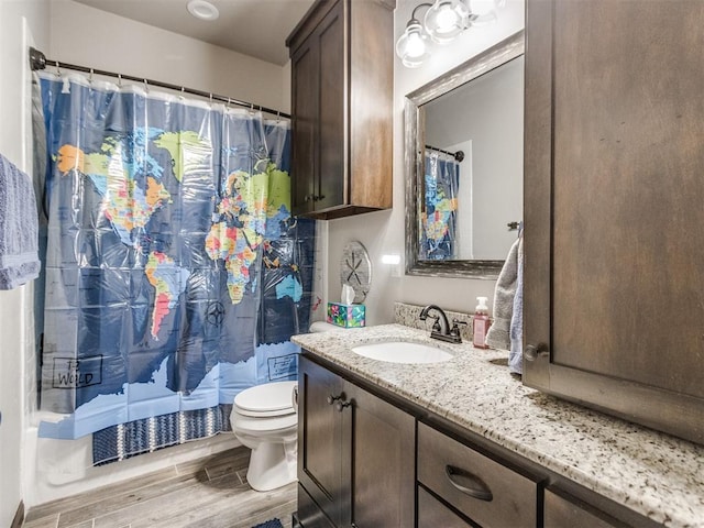 bathroom featuring toilet, a shower with shower curtain, vanity, and wood finish floors