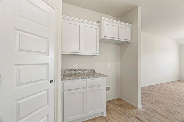 4605 Lincoln Lndg, Harrah, OK 73045 - kitchen with light wood finished floors, baseboards, light stone counters, and white cabinetry