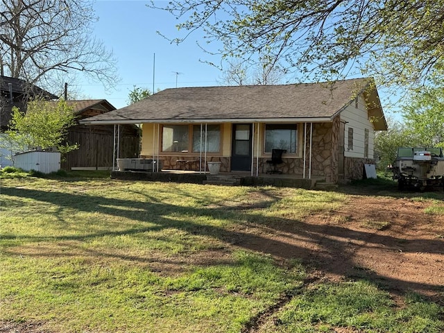 1709 Fisherman Rd, Carnegie, OK 73015 - back of property with roof with shingles, stone siding, a lawn, and covered porch