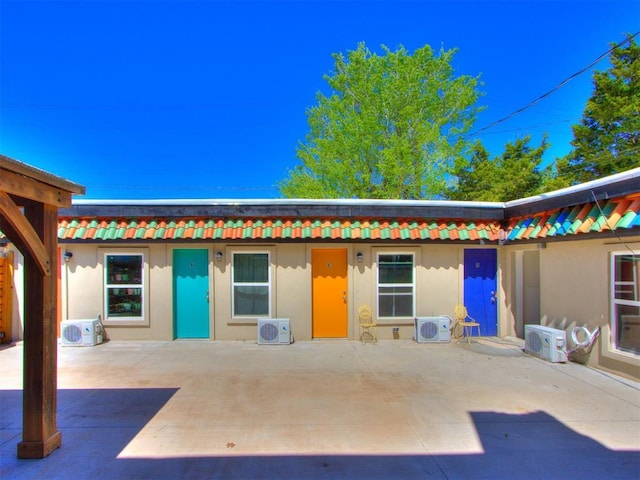 225 NW 24th St, Oklahoma City, OK 73103 - exterior space with a patio area, ac unit, a tiled roof, and stucco siding