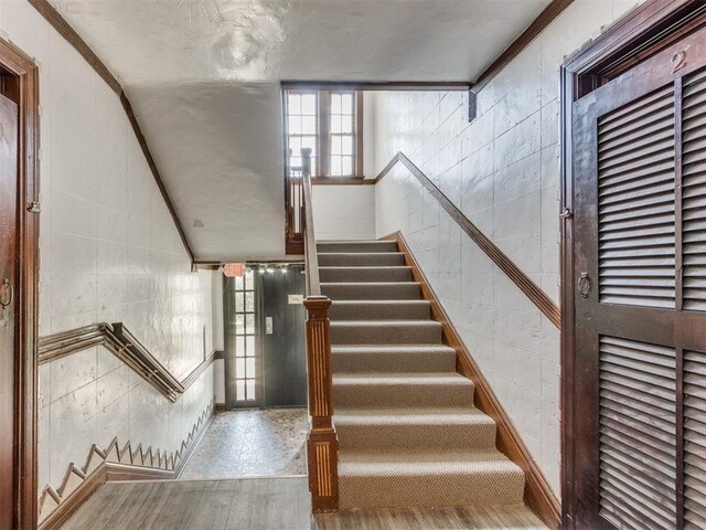 225 NW 24th St, Oklahoma City, OK 73103 - staircase featuring tile walls, plenty of natural light, and wood finished floors