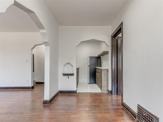 225 NW 24th St, Oklahoma City, OK 73103 - corridor featuring visible vents, baseboards, arched walkways, and wood finished floors
