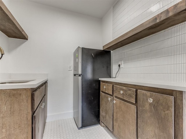 225 NW 24th St, Oklahoma City, OK 73103 - kitchen with freestanding refrigerator, light tile patterned floors, open shelves, light countertops, and baseboards