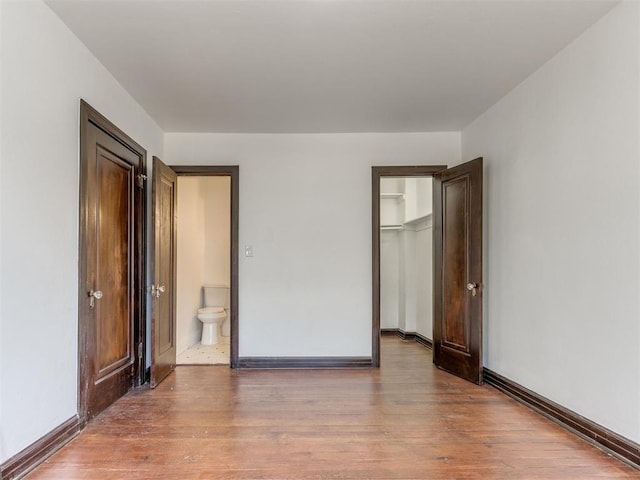 225 NW 24th St, Oklahoma City, OK 73103 - unfurnished bedroom featuring a closet, baseboards, and wood finished floors