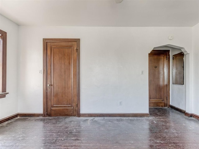 225 NW 24th St, Oklahoma City, OK 73103 - empty room featuring baseboards, arched walkways, and wood finished floors