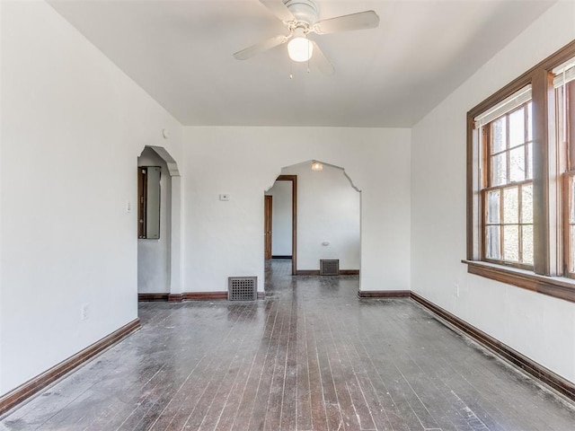 225 NW 24th St, Oklahoma City, OK 73103 - empty room with ceiling fan, arched walkways, visible vents, baseboards, and hardwood / wood-style flooring