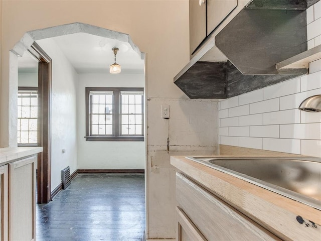 225 NW 24th St, Oklahoma City, OK 73103 - kitchen with decorative backsplash, light countertops, wood finished floors, and a healthy amount of sunlight