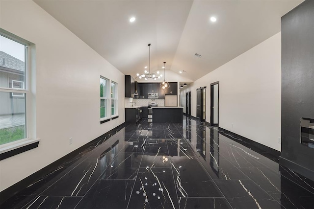 528 NW 112th St, Oklahoma City, OK 73114 - kitchen with vaulted ceiling, light countertops, a chandelier, stainless steel appliances, and a kitchen island