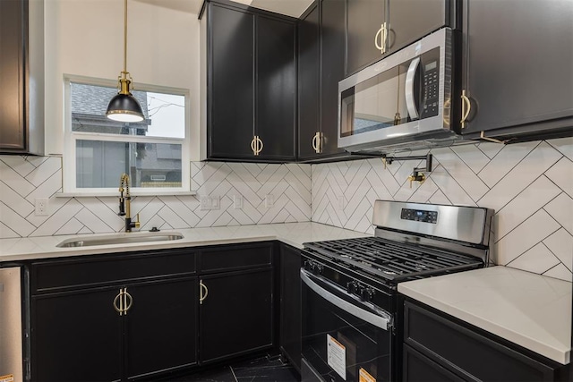 528 NW 112th St, Oklahoma City, OK 73114 - kitchen featuring stainless steel appliances, dark cabinets, a sink, and light countertops