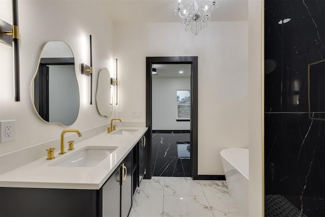 528 NW 112th St, Oklahoma City, OK 73114 - full bath with marble finish flooring, a freestanding bath, double vanity, baseboards, and a chandelier