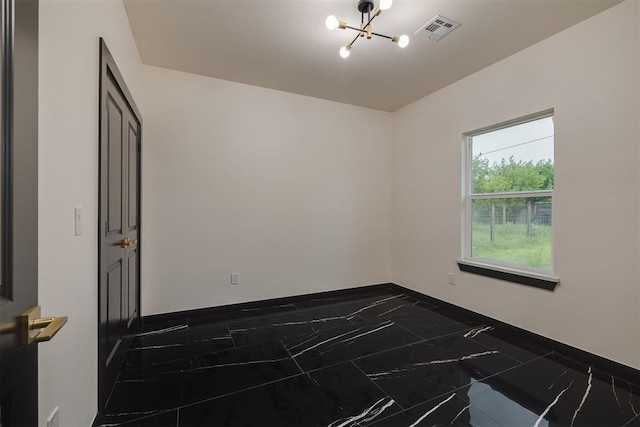528 NW 112th St, Oklahoma City, OK 73114 - empty room featuring a chandelier, dark marble finish flooring, and baseboards