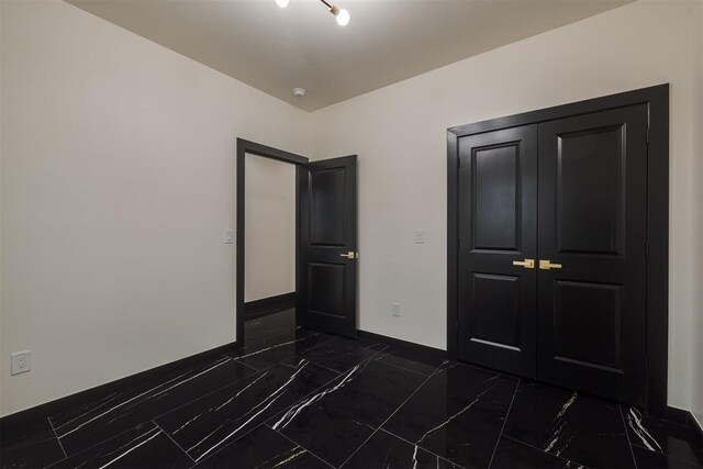 528 NW 112th St, Oklahoma City, OK 73114 - unfurnished bedroom with dark marble finish flooring, baseboards, and a closet