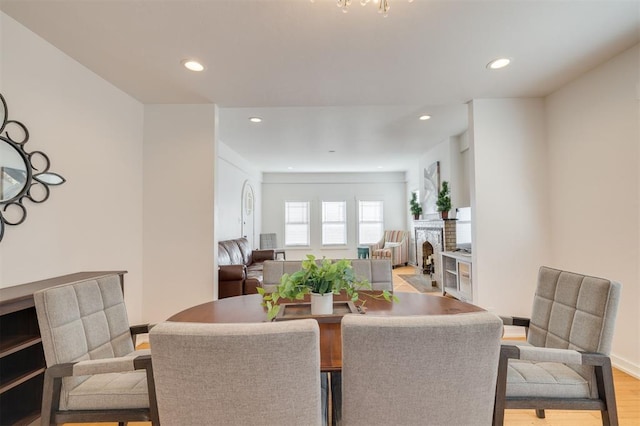 dining area with light wood-style floors, a fireplace, and recessed lighting