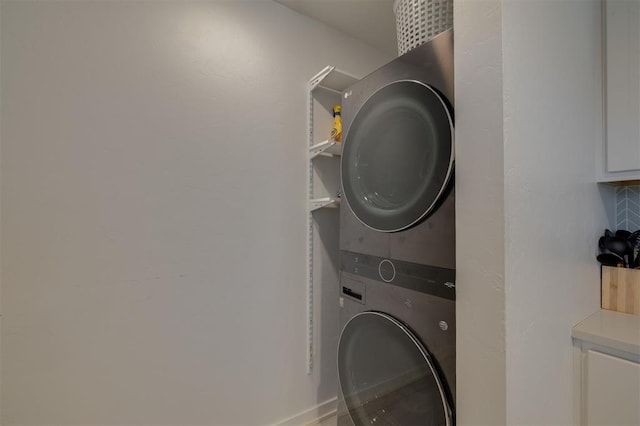 clothes washing area featuring stacked washer and clothes dryer