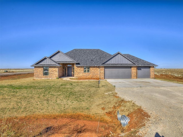view of front of house with concrete driveway, a front yard, brick siding, and a garage