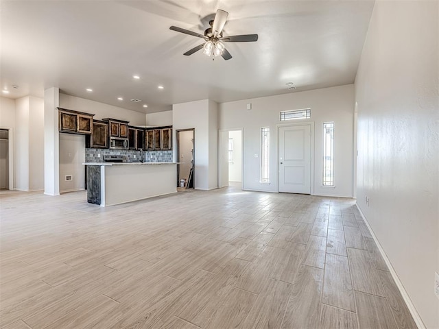 unfurnished living room featuring baseboards, light wood-type flooring, recessed lighting, and a ceiling fan