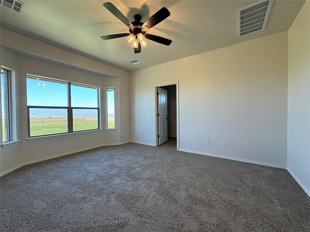empty room featuring ceiling fan, baseboards, and visible vents