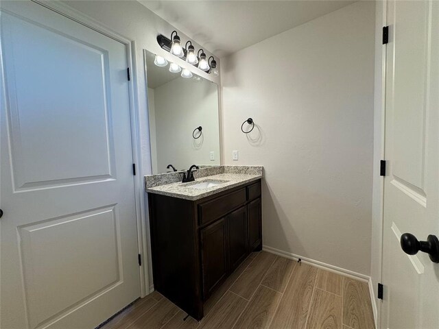 bathroom with vanity, baseboards, and wood tiled floor