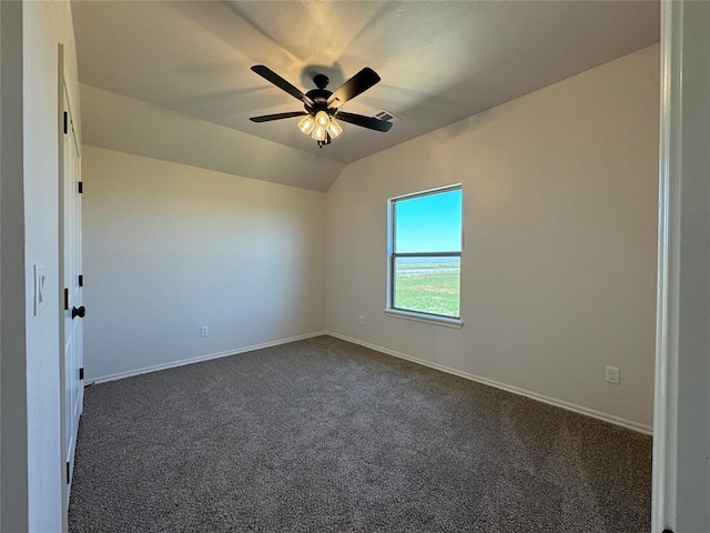 empty room featuring dark colored carpet, baseboards, vaulted ceiling, visible vents, and ceiling fan