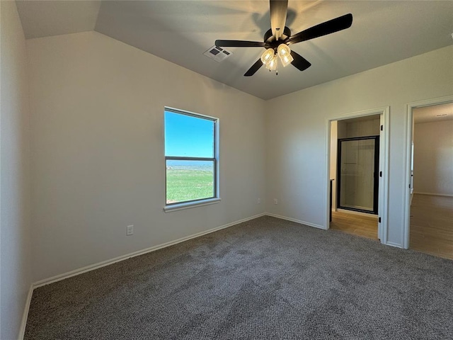 unfurnished bedroom featuring visible vents, baseboards, a ceiling fan, carpet, and lofted ceiling