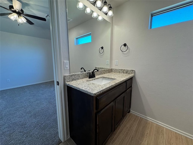 bathroom featuring vanity, baseboards, a ceiling fan, and a healthy amount of sunlight