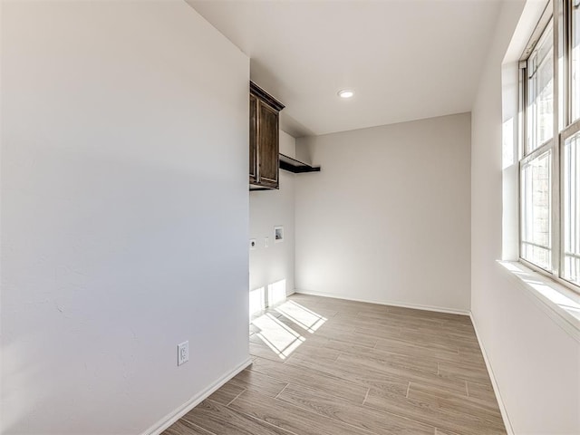 unfurnished room with light wood finished floors and baseboards