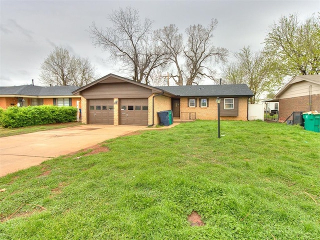 single story home featuring a garage, concrete driveway, brick siding, and a front lawn