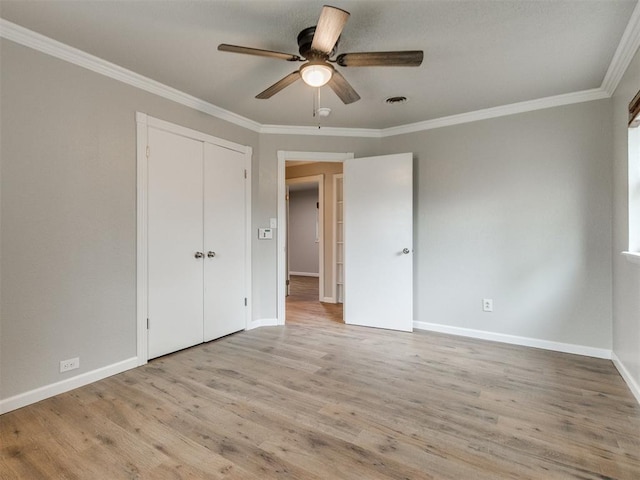 unfurnished bedroom with light wood finished floors, baseboards, and crown molding