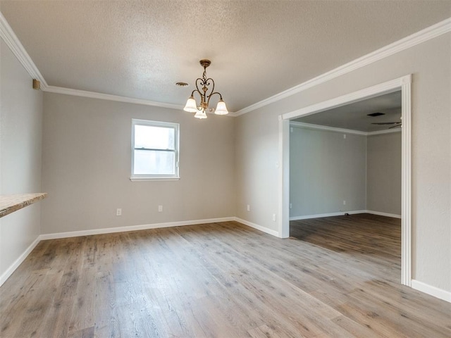 empty room with a chandelier, crown molding, wood finished floors, and a textured ceiling