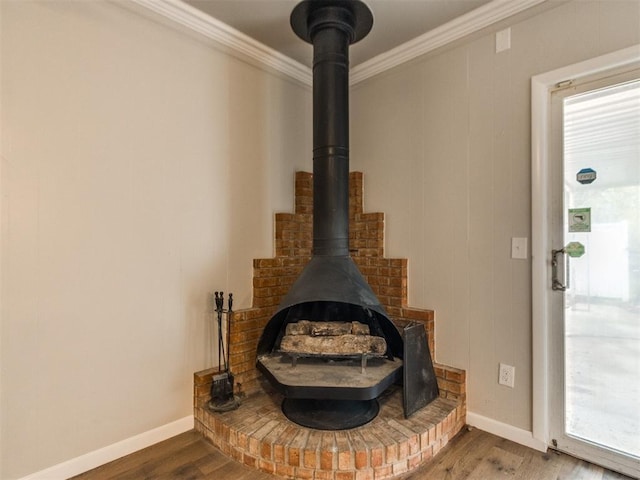 interior details with ornamental molding, a wood stove, wood finished floors, and baseboards