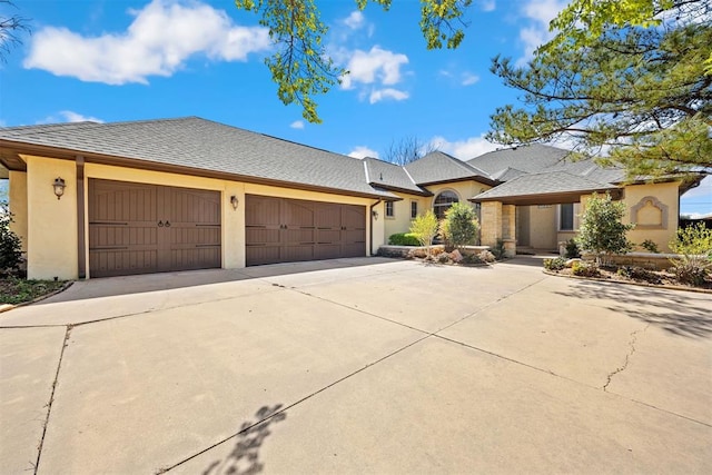 13125 Oakcliff Rd, Oklahoma City, OK 73120 - view of front of house featuring a shingled roof, driveway, stucco siding, and an attached garage