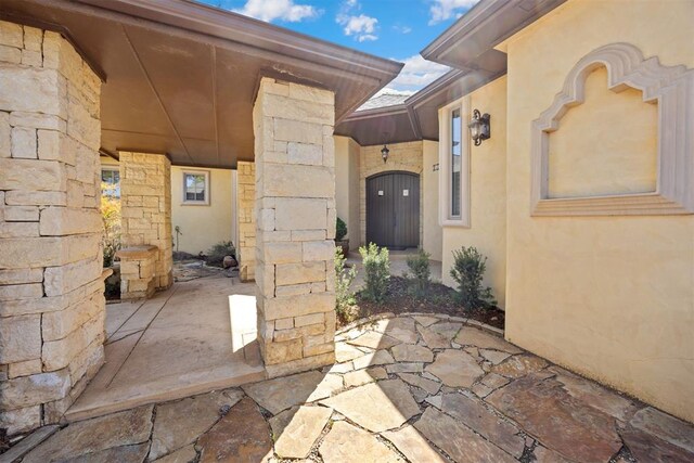 13125 Oakcliff Rd, Oklahoma City, OK 73120 - entrance to property featuring a patio area, stone siding, and stucco siding