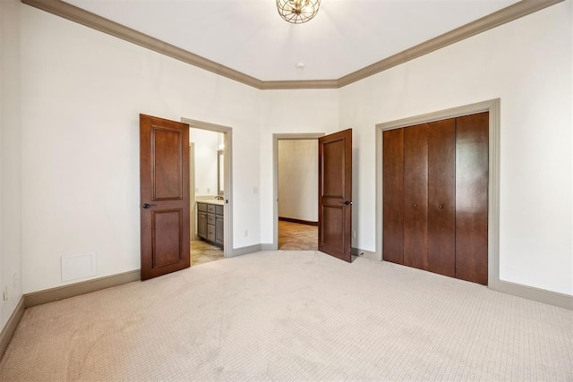 13125 Oakcliff Rd, Oklahoma City, OK 73120 - unfurnished bedroom with a closet, baseboards, ensuite bathroom, crown molding, and light colored carpet