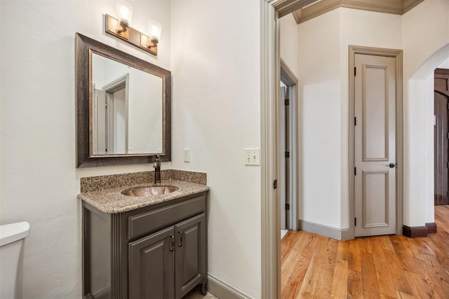 13125 Oakcliff Rd, Oklahoma City, OK 73120 - half bathroom featuring toilet, wood finished floors, vanity, and baseboards