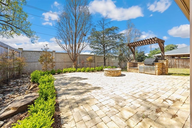 13125 Oakcliff Rd, Oklahoma City, OK 73120 - view of patio / terrace featuring a fenced backyard, a pergola, a fire pit, and exterior kitchen