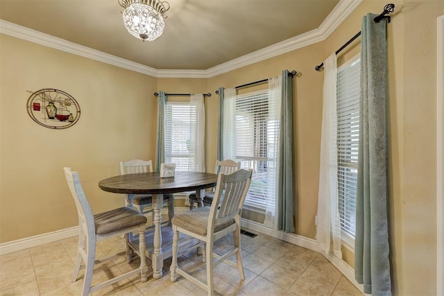dining space with light tile patterned floors, an inviting chandelier, baseboards, ornamental molding, and visible vents