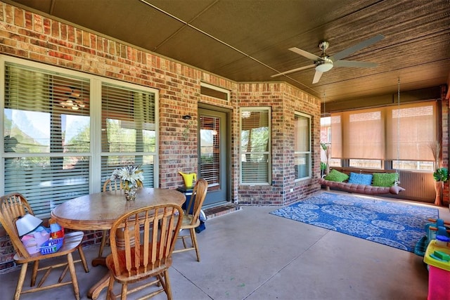 sunroom / solarium featuring a ceiling fan, outdoor dining space, and plenty of natural light