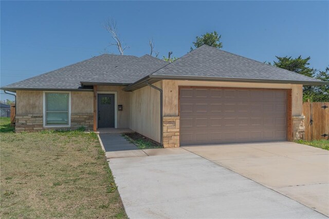 1800 N Nebraska Ave, Oklahoma City, OK 73111 - view of front of house with roof with shingles, a front yard, stone siding, an attached garage, and concrete driveway