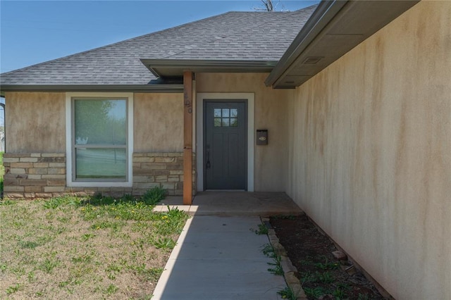 1800 N Nebraska Ave, Oklahoma City, OK 73111 - doorway to property featuring roof with shingles, stucco siding, and stone siding