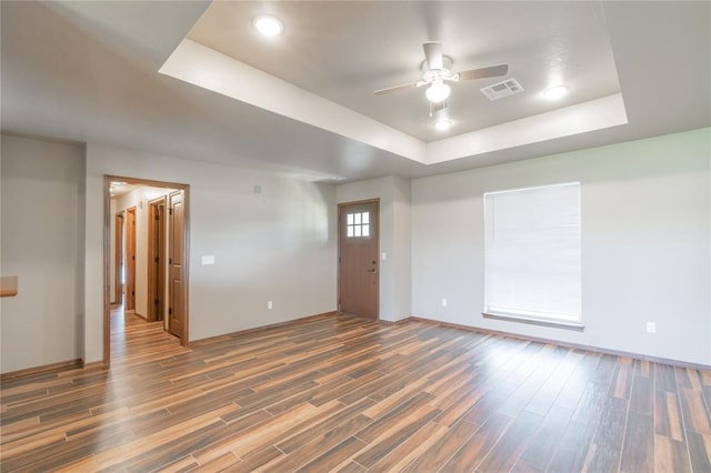 1800 N Nebraska Ave, Oklahoma City, OK 73111 - unfurnished living room featuring visible vents, baseboards, a ceiling fan, a tray ceiling, and wood finished floors