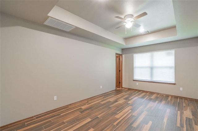 1800 N Nebraska Ave, Oklahoma City, OK 73111 - unfurnished room with visible vents, a ceiling fan, a tray ceiling, and wood finished floors