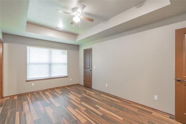 1800 N Nebraska Ave, Oklahoma City, OK 73111 - empty room with visible vents, a tray ceiling, a ceiling fan, and wood finished floors