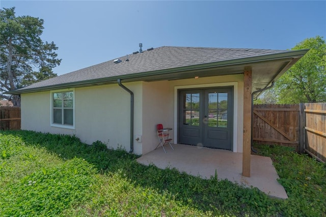 1800 N Nebraska Ave, Oklahoma City, OK 73111 - back of property featuring fence, a patio, stucco siding, french doors, and roof with shingles
