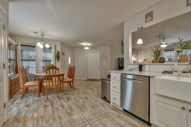 kitchen with hanging light fixtures, dishwasher, white cabinetry, and light wood-style flooring