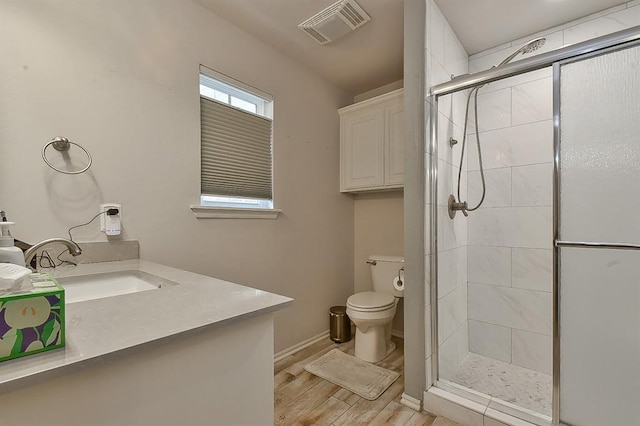 full bathroom with visible vents, baseboards, toilet, wood finished floors, and a stall shower